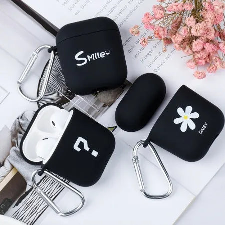 Black and pink AirPods earphone covers with decorative flower and smiley face back designs.