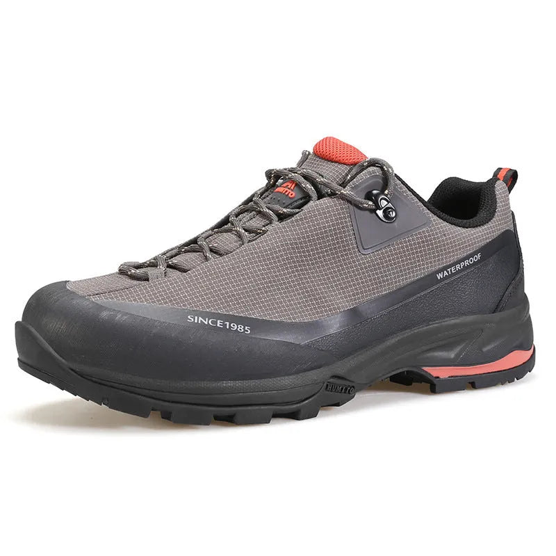 Men's low-top hiking boots in black with leather mesh upper and rubber outsole on a rocky path.