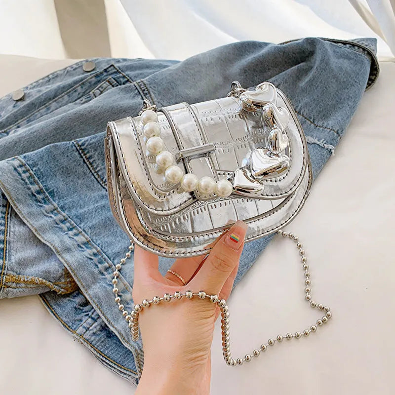 Women's silver PU crossbody bag showing horizontal square tote saddle shape and single shoulder strap