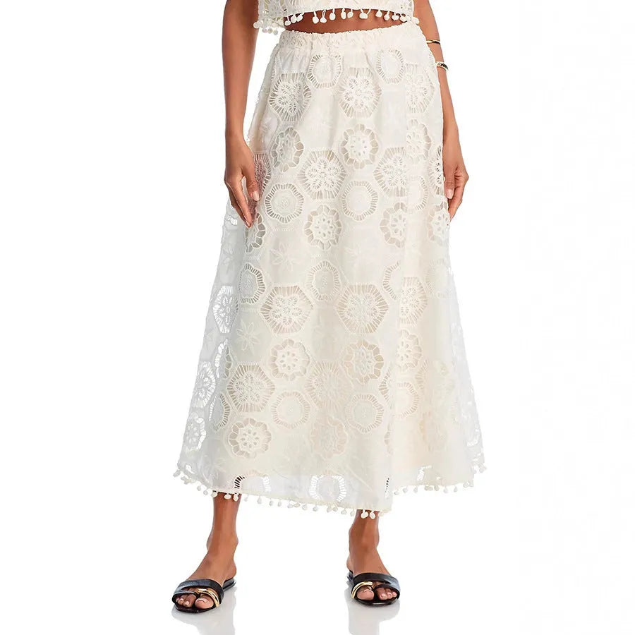 White women's sleeveless top and long skirt suit with embroidery detail on a mannequin.