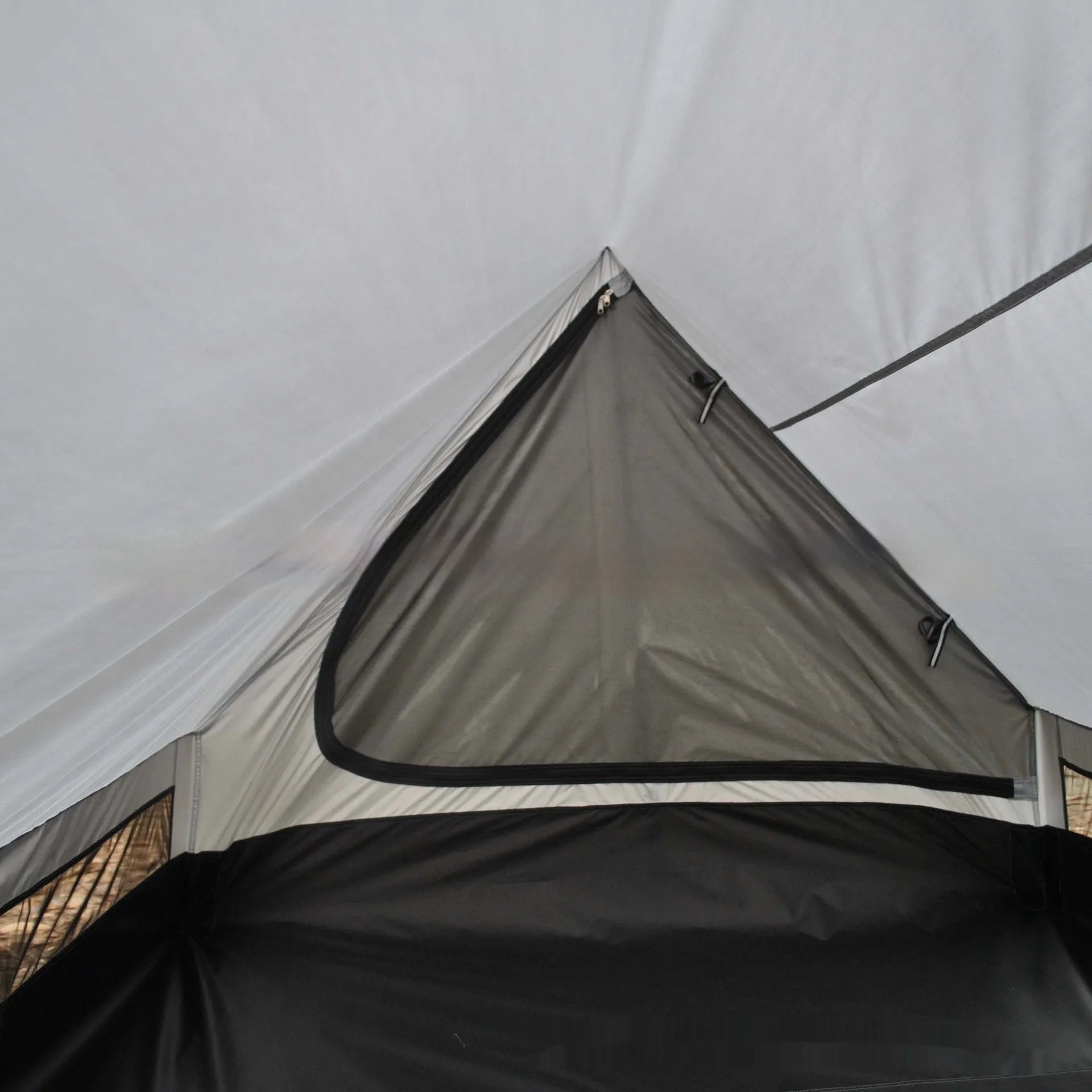 Brown and white pole-free A-line cabin tent set up with hiking canes, showing spacious interior