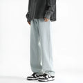 Men's light blue washed straight leg jeans with button waist on a plain background.