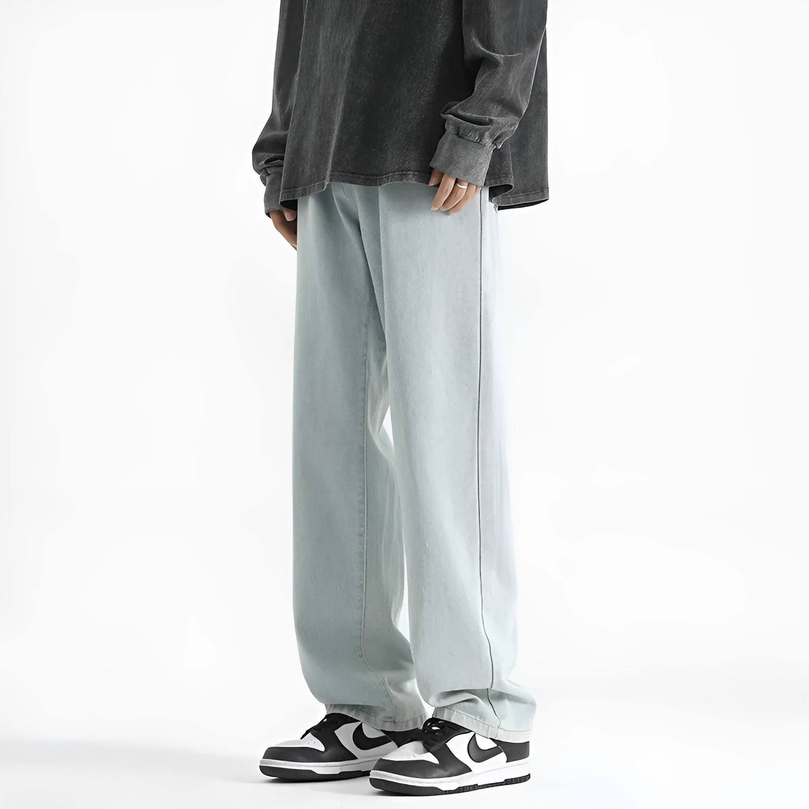 Men's light blue washed straight leg jeans with button waist on a plain background.