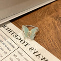 Copper butterfly women's ring on a plain background showing the simple design and metallic finish.