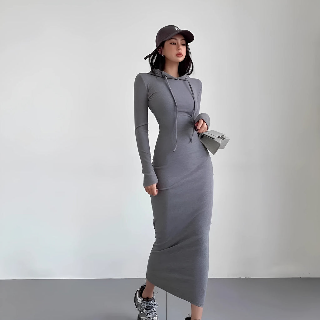 A woman modelling a grey hooded long sleeve sheath dress with a high waist.