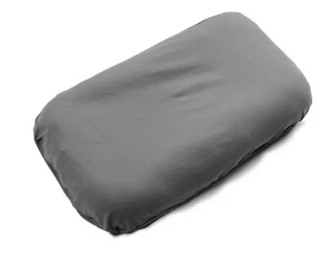 Beige portable cotton baby nest crib for newborn infants on a bed.