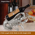 Lobster-shaped wine rack ornament in rose gold or silver, holding a wine bottle.