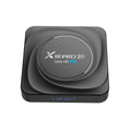 Compact black Android 11 TV box with HDMI port, remote control, and power supply on a wooden surface.
