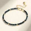 Close-up of a blue tourmaline beaded bracelet with metallic spacer beads on a woman's wrist.