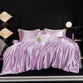 Silk bed sheet four-piece set in a solid colour, shown draped over a bed in one of seven available colours.