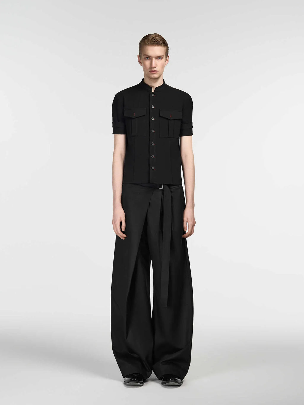 Black loose-fit straight-leg trousers with a single pleat and adjustable mid waist on a hanger.