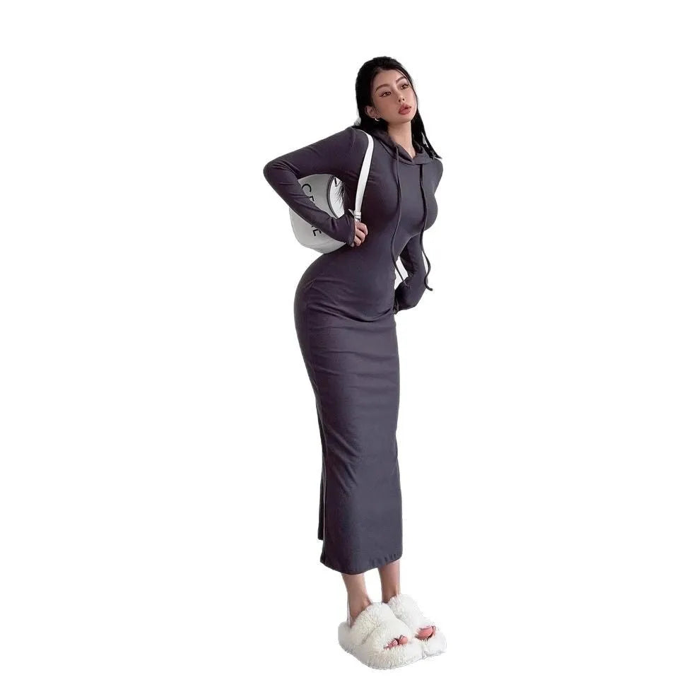 A woman modelling a grey hooded long sleeve sheath dress with a high waist.