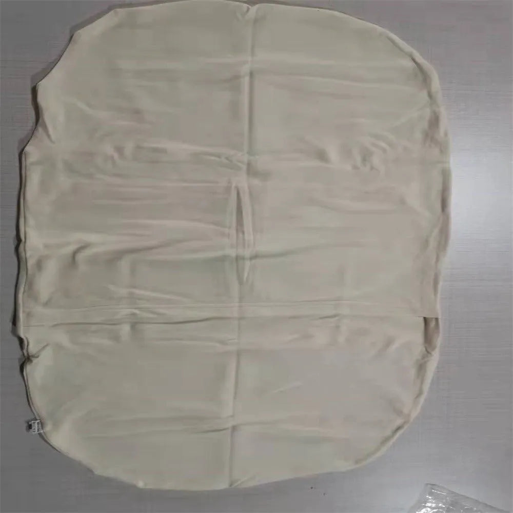Beige portable cotton baby nest crib for newborn infants on a bed.