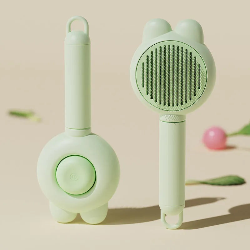 Green self-cleaning pet grooming brush with release button and stainless steel comb teeth.