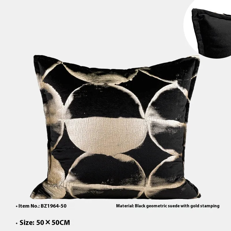Black and gold abstract patterned square cushion on a grey sofa