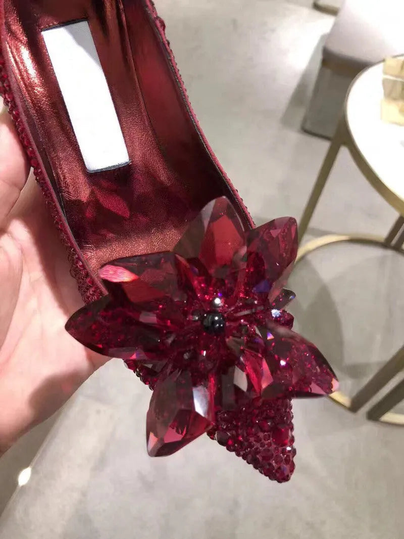 Women's gold pointed toe stiletto heels decorated with rhinestones and a bow