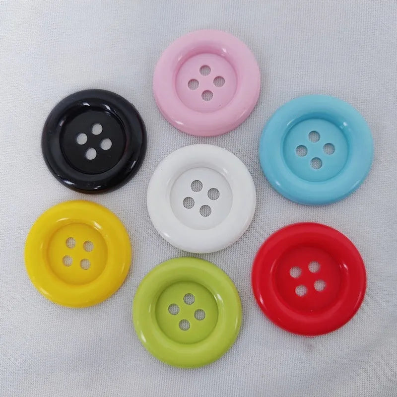 Oversized round plastic nylon button with four holes in various colours and sizes