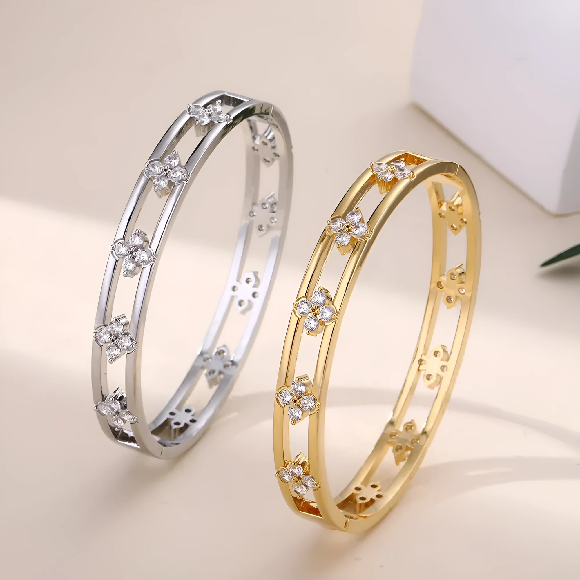 Gold and silver hollow women's bracelet with four-leaf clover design and zircon inlay.