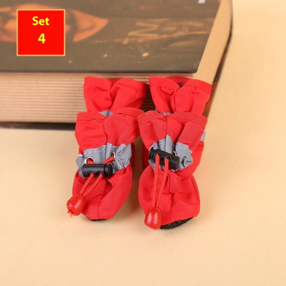 Set of four cloth dog shoes with soft soles in assorted colours on a neutral background