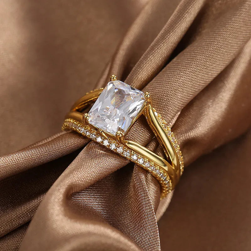 Gold geometric women's ring with a square zircon stone on a copper band.