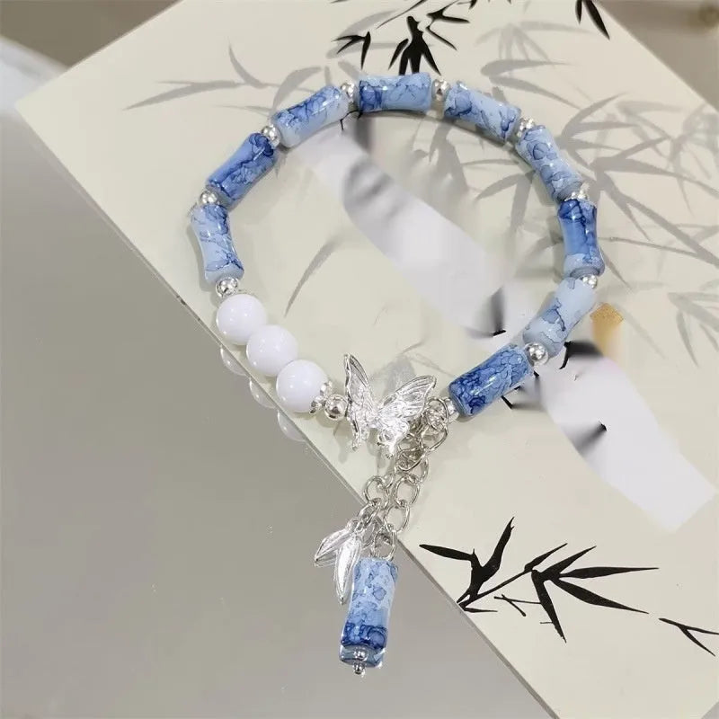 Chinese style handmade glass bead bracelet with bamboo joint elements on a white background.
