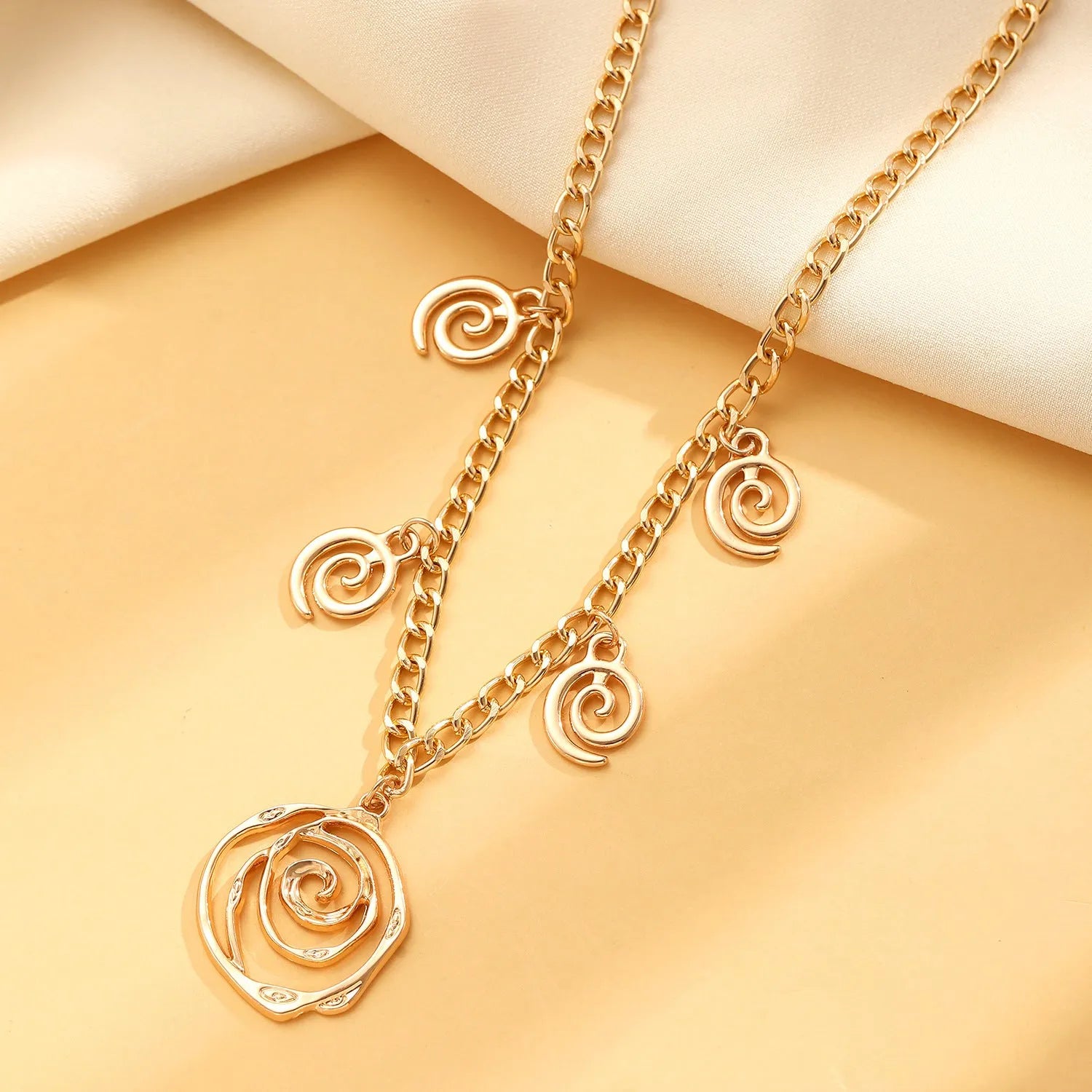 Spiral donut jewellery set with necklace, bracelet and ear hooks in gold or silver tone