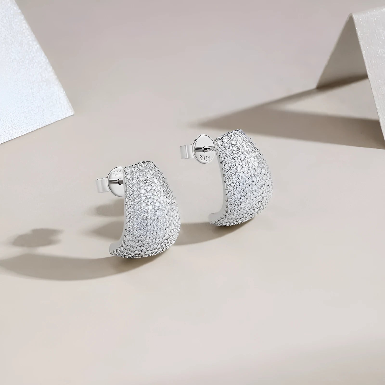 Geometric shaped S925 sterling silver ear studs with moissanite stones, shown with alloy backs.