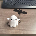 Mini resin figurine of a ghost walking a small dog, a 4x5x4cm Halloween decoration.