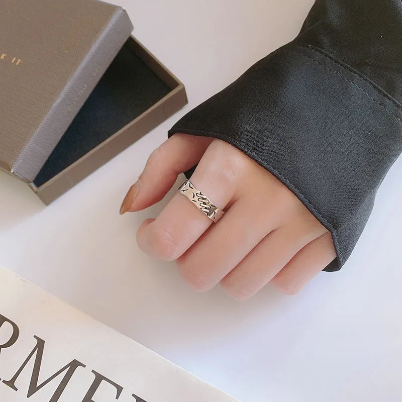 Black geometric copper ring with adjustable opening featuring round and oval design elements