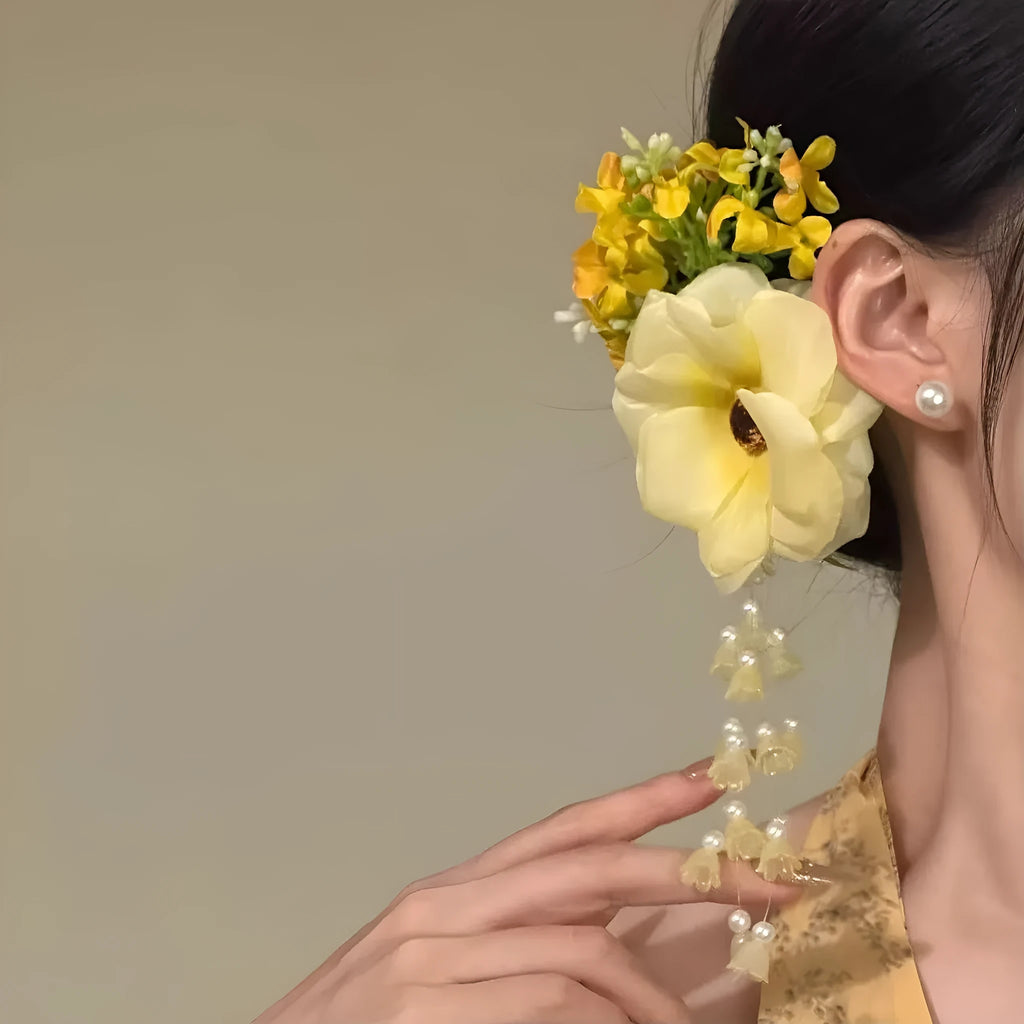 Close-up of a handmade floral tassel hair clip in yellow with a side clip.