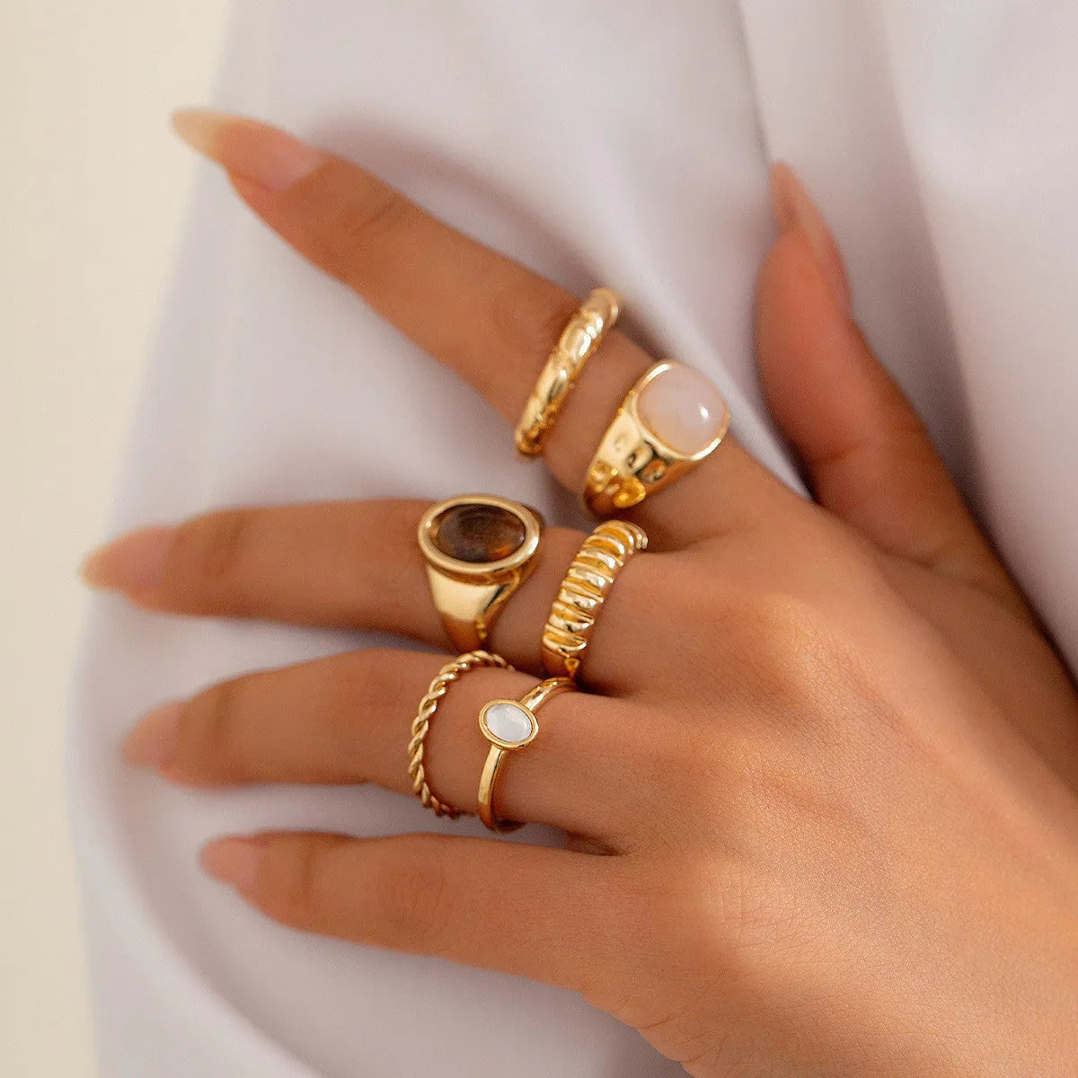 Six geometric alloy rings with light gold electroplating arranged as a set