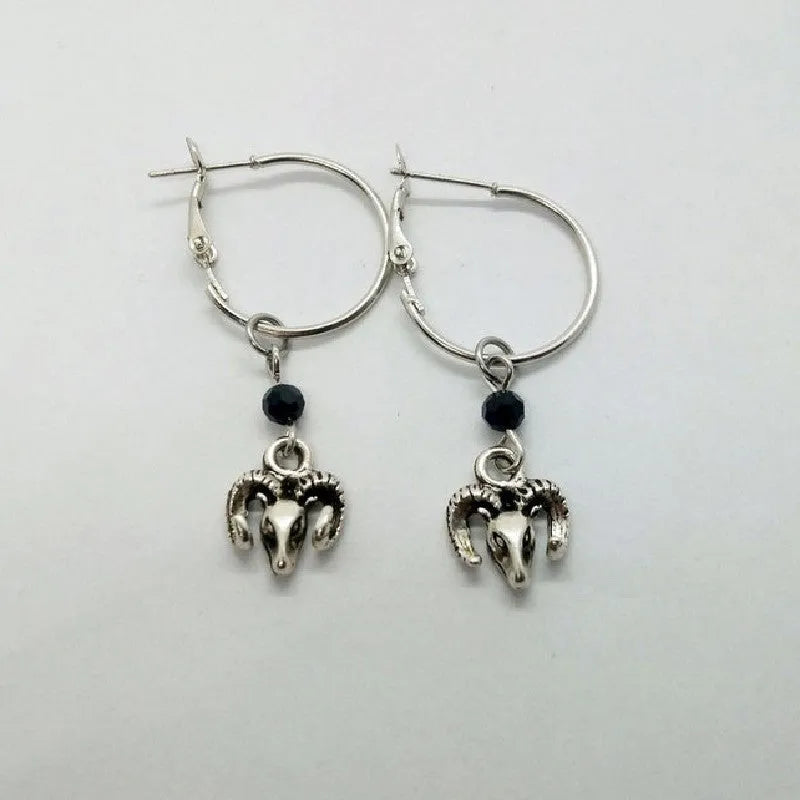 Silver-coloured alloy round earrings with a raised Tibetan antelope design.
