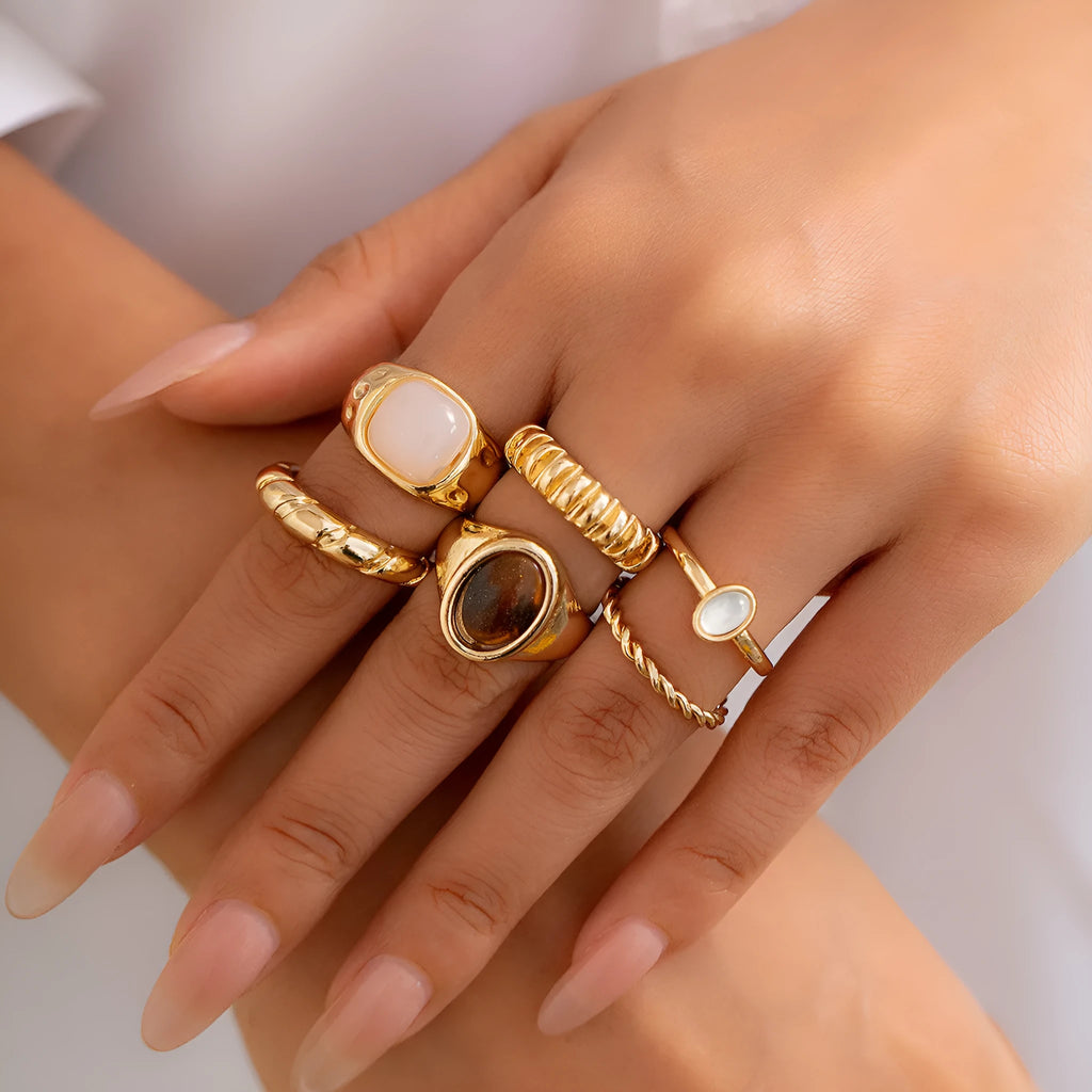 Six geometric alloy rings with light gold electroplating arranged as a set