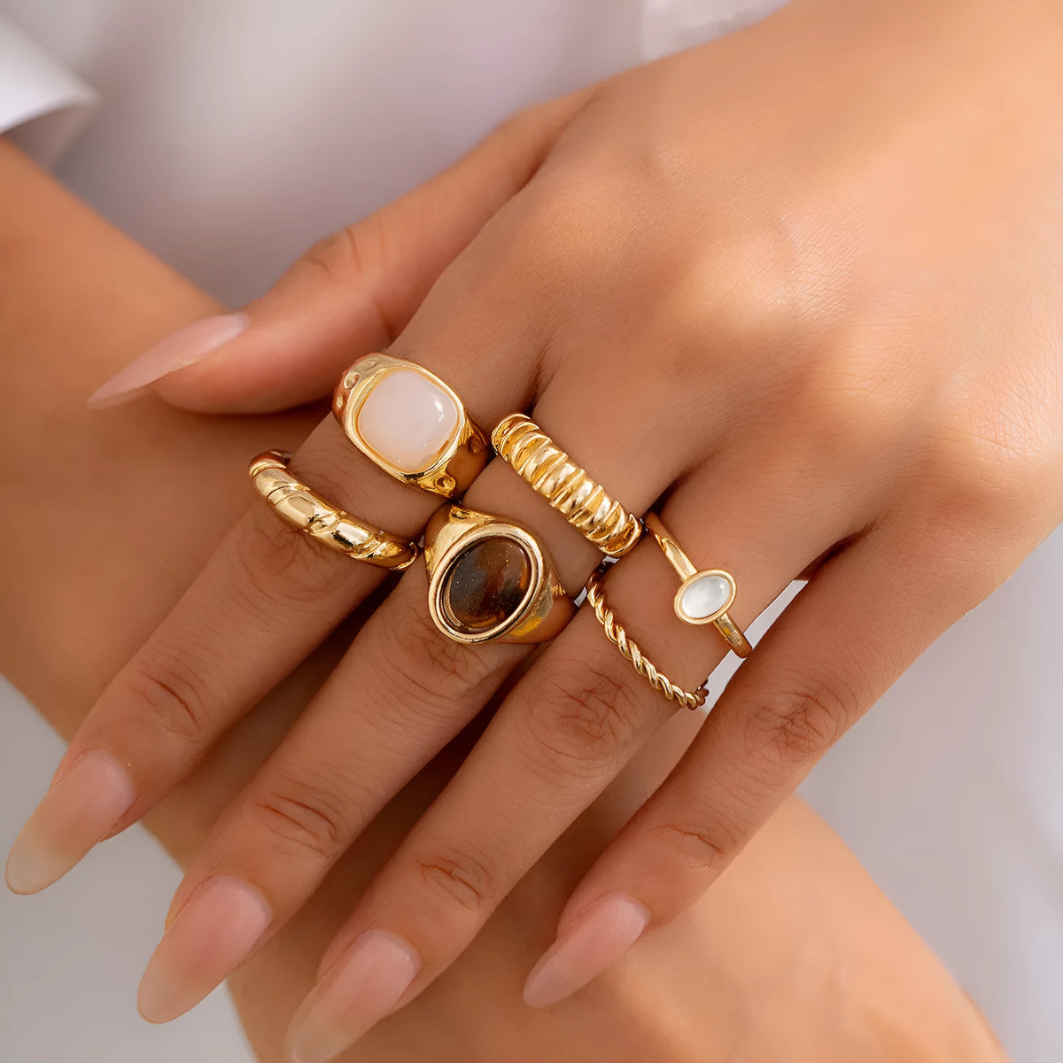 Six geometric alloy rings with light gold electroplating arranged as a set
