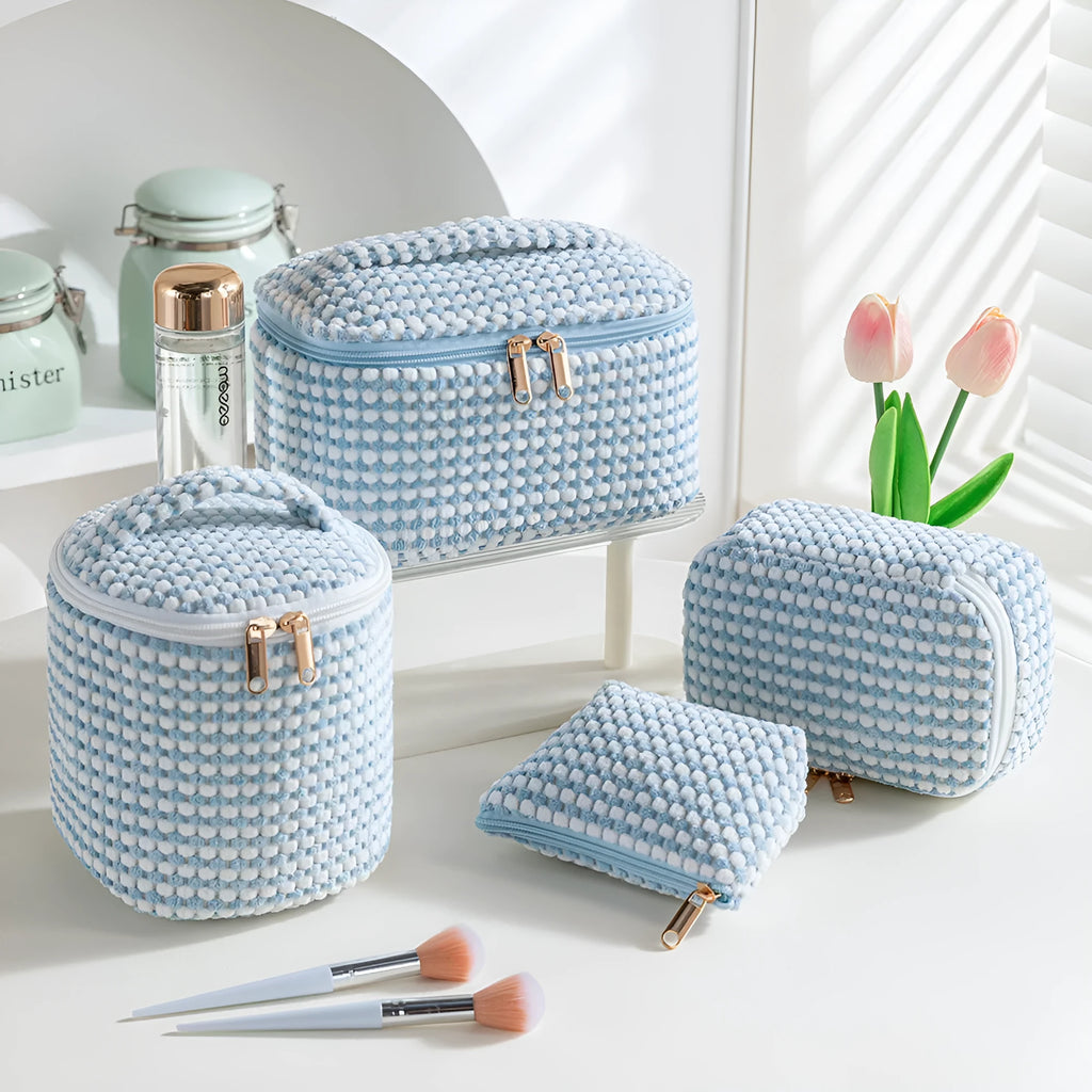Four cube-style flannelette makeup bags in matching colour set on white background
