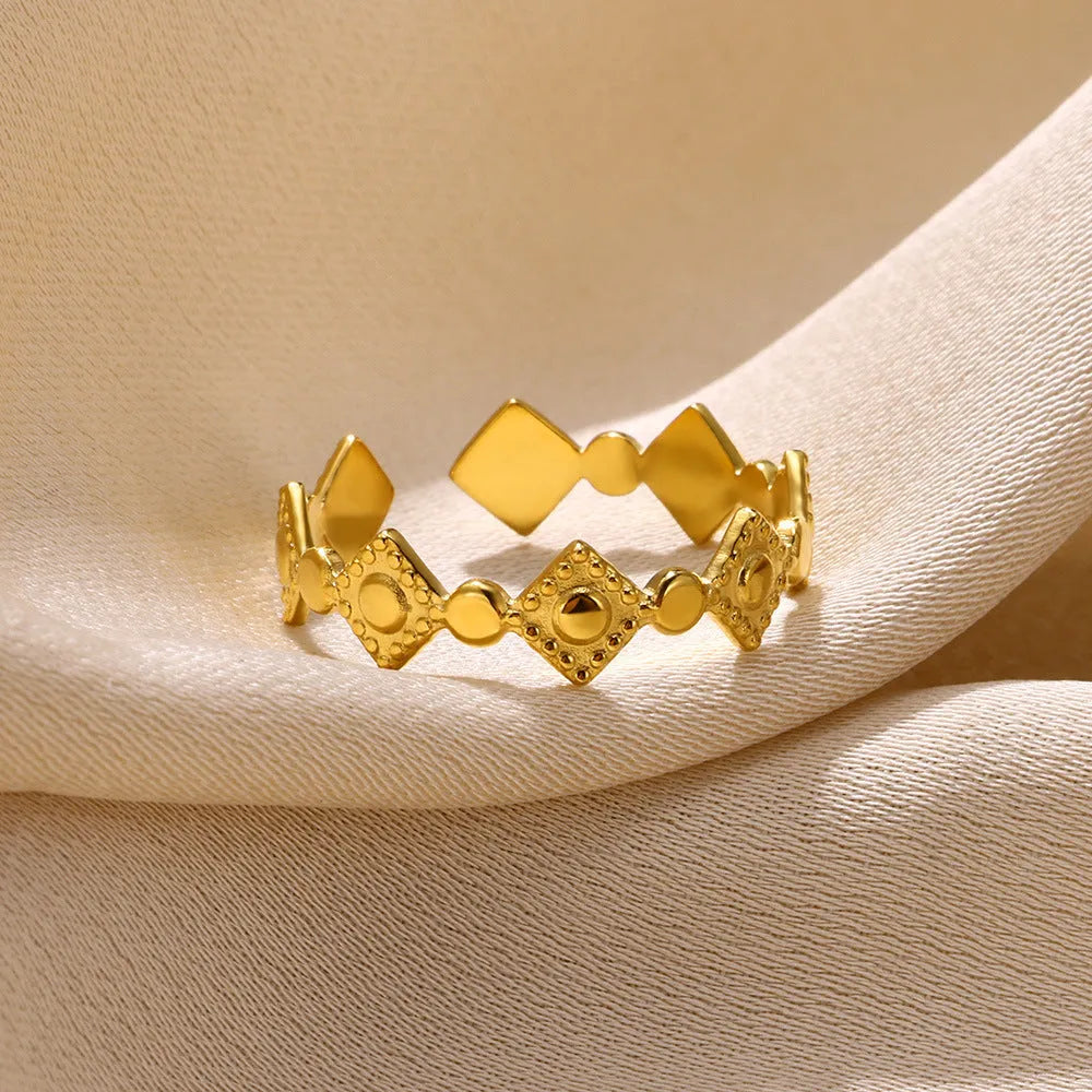 Gold geometric titanium steel women's ring with diamond accents on grey background