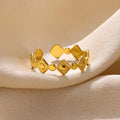 Gold geometric titanium steel women's ring with diamond accents on grey background