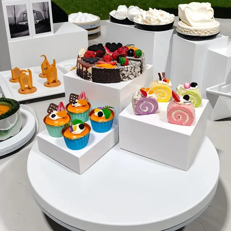 White plastic suit cube dessert display stand with six individual cubes for wedding cakes and pastries.