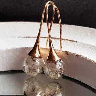 Transparent glass ball earrings with dandelion seed design inside, shown with French hooks