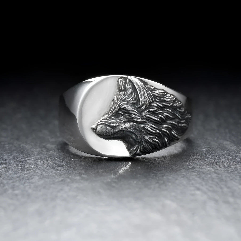 Geometric silver alloy wolf head signet ring for men on a grey background.
