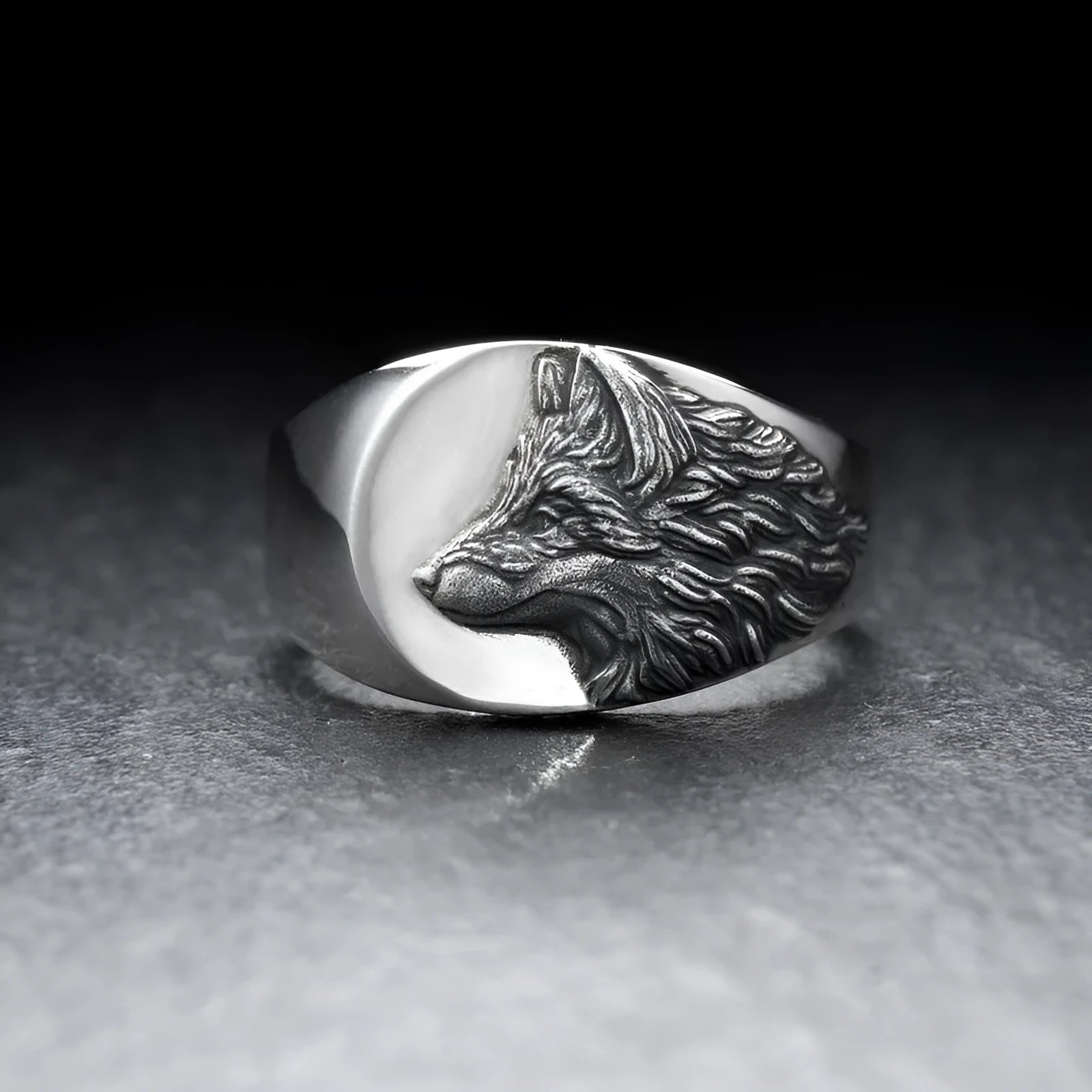 Geometric silver alloy wolf head signet ring for men on a grey background.