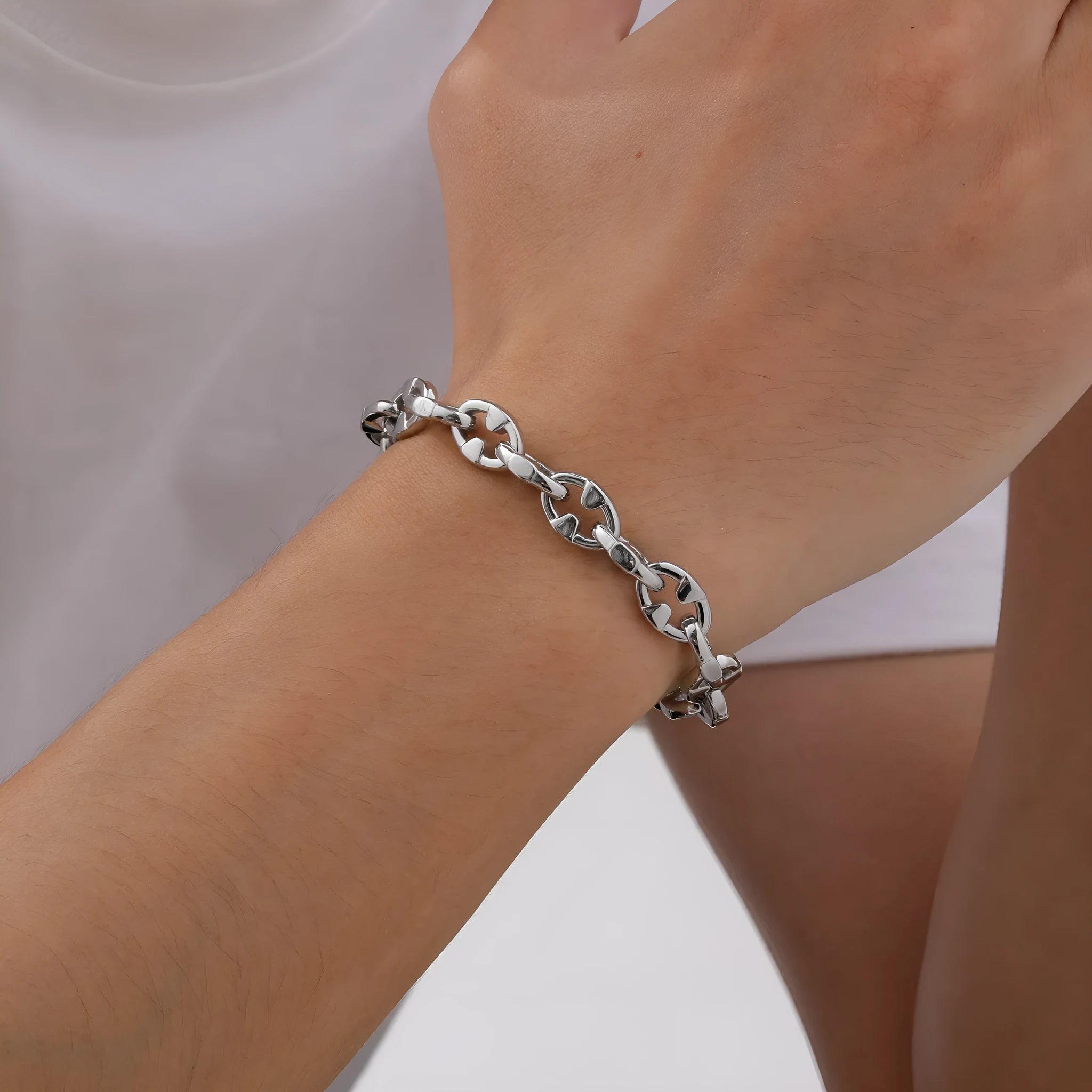 Handmade thick stainless steel geometric chain bracelet for men on a grey background.