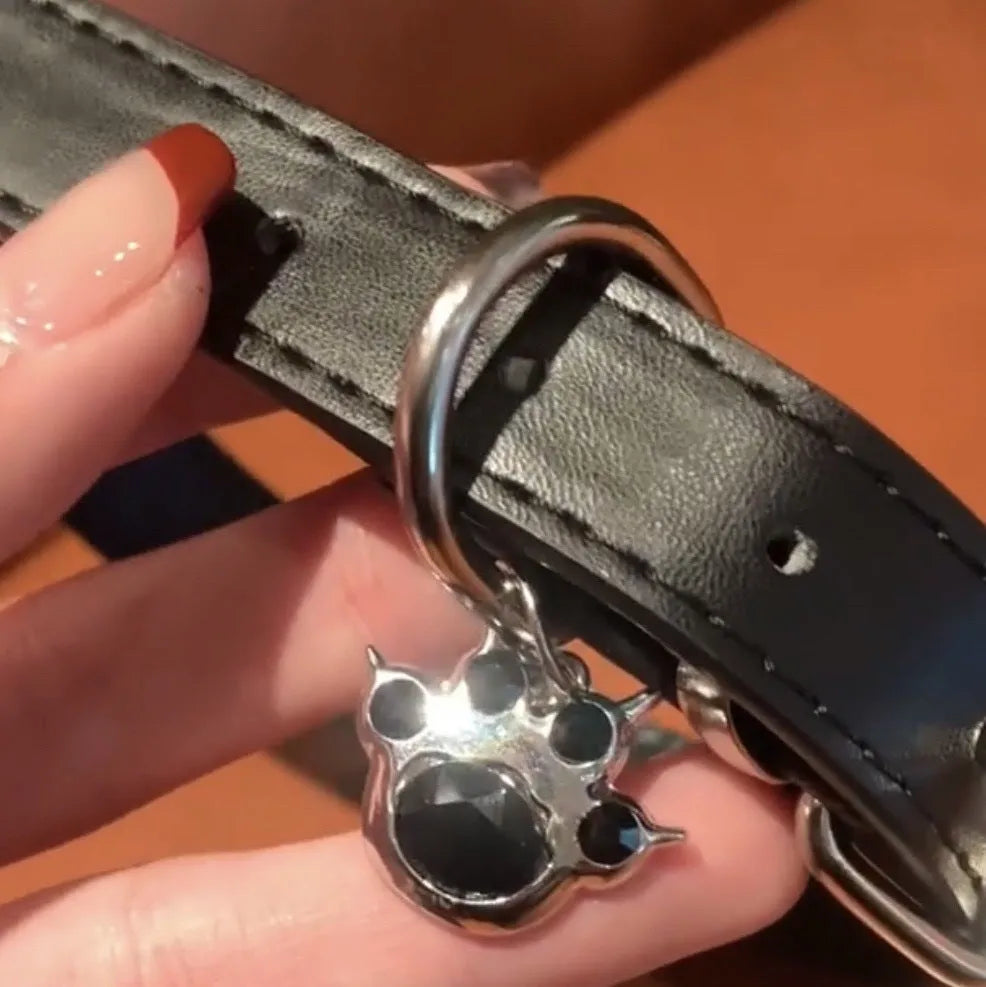 Black adjustable dog collar with a bell charm, shown in LD leather, cute bone, and cute cat paw designs.