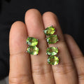 Close-up of natural grass green olivine stud earrings in S925 sterling silver settings.