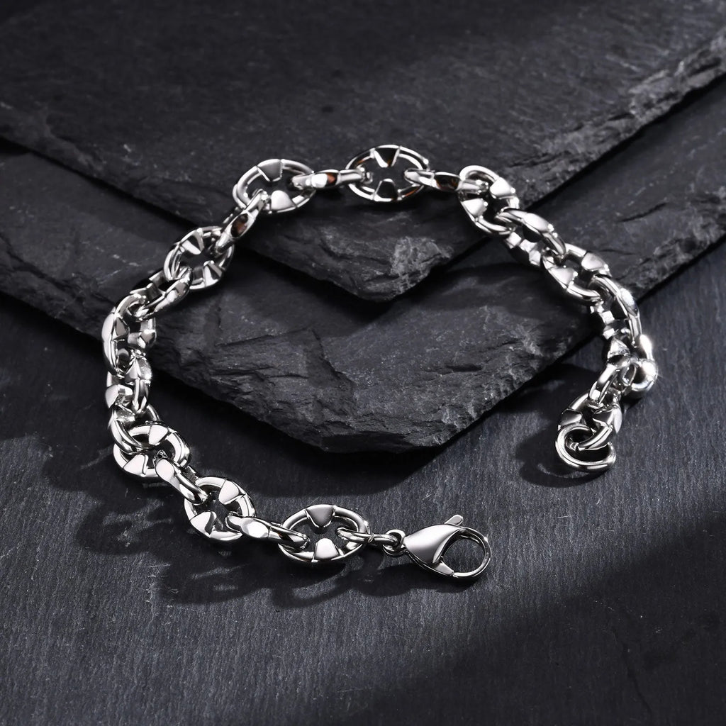 Handmade thick stainless steel geometric chain bracelet for men on a grey background.