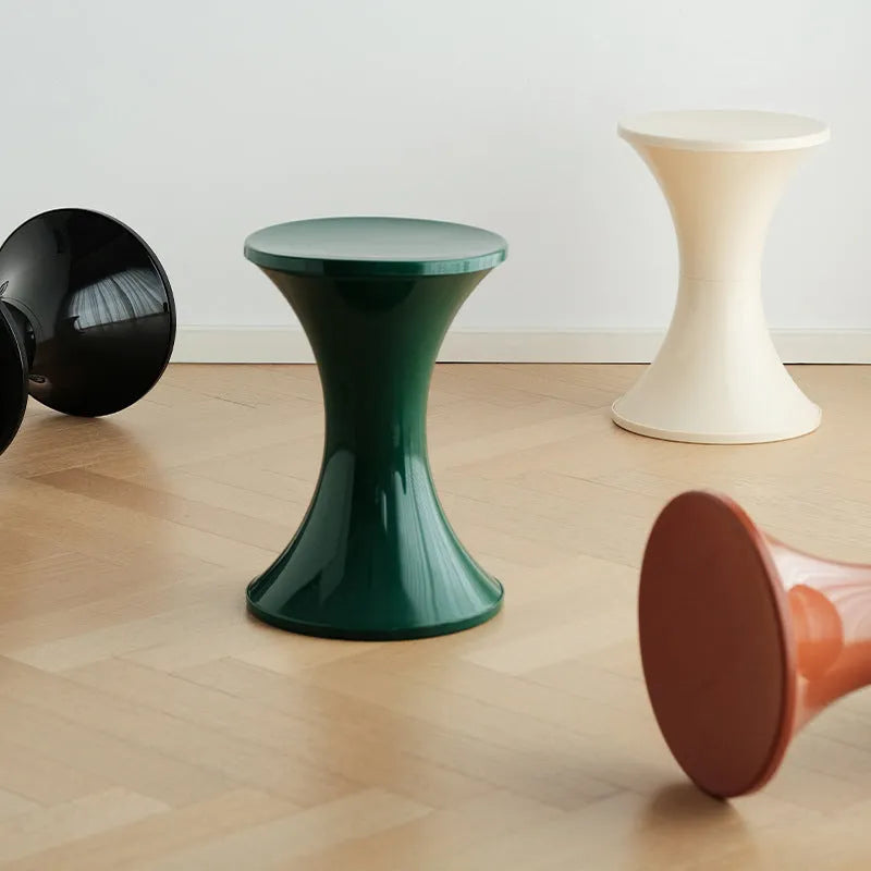 A plastic hourglass-style shoe changing stool in one of five available colours: black, green, red, white, or brown.