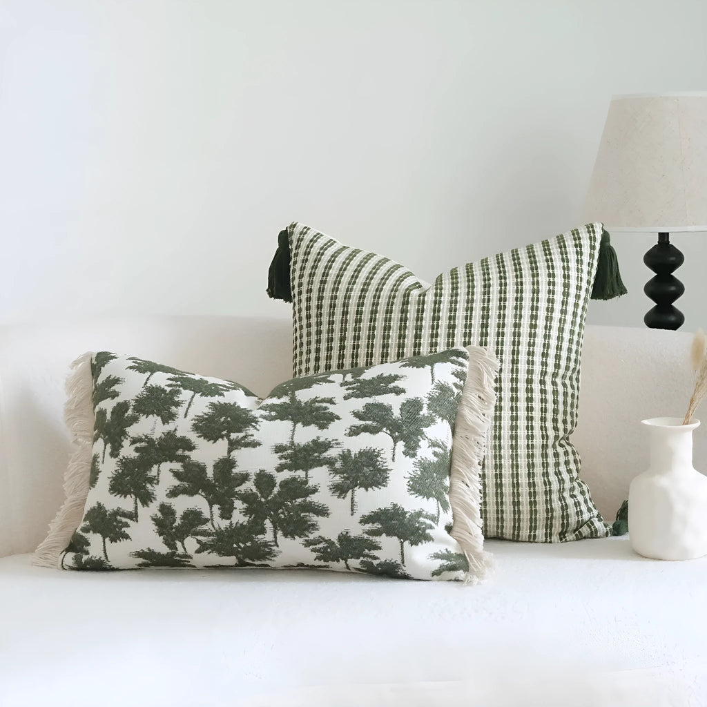 Green decorative pillow with botanical embroidery on cotton linen fabric, shown with tassel and bead details.