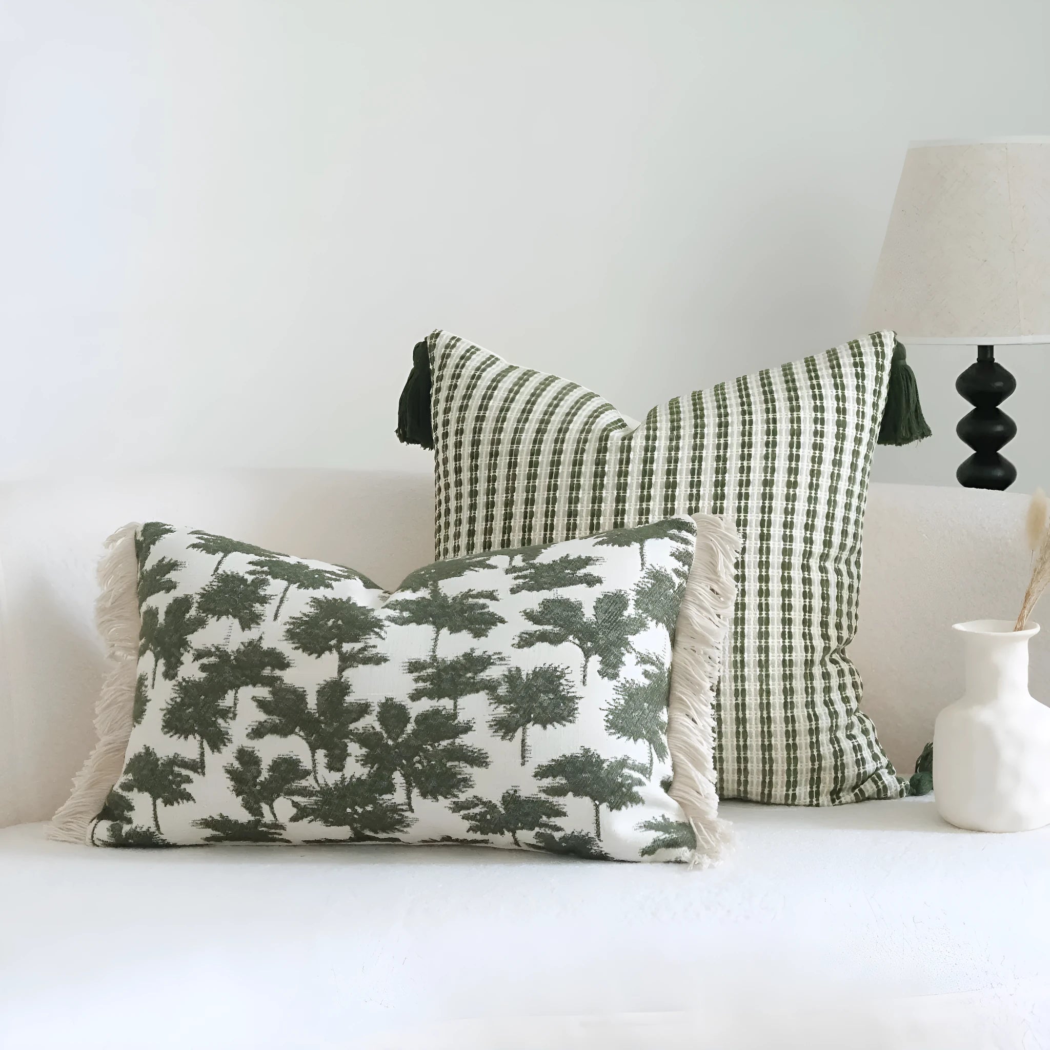 Green decorative pillow with botanical embroidery on cotton linen fabric, shown with tassel and bead details.