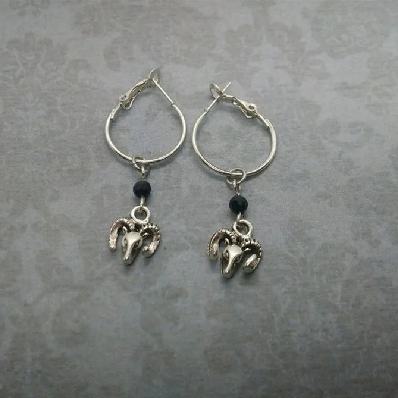 Silver-coloured alloy round earrings with a raised Tibetan antelope design.