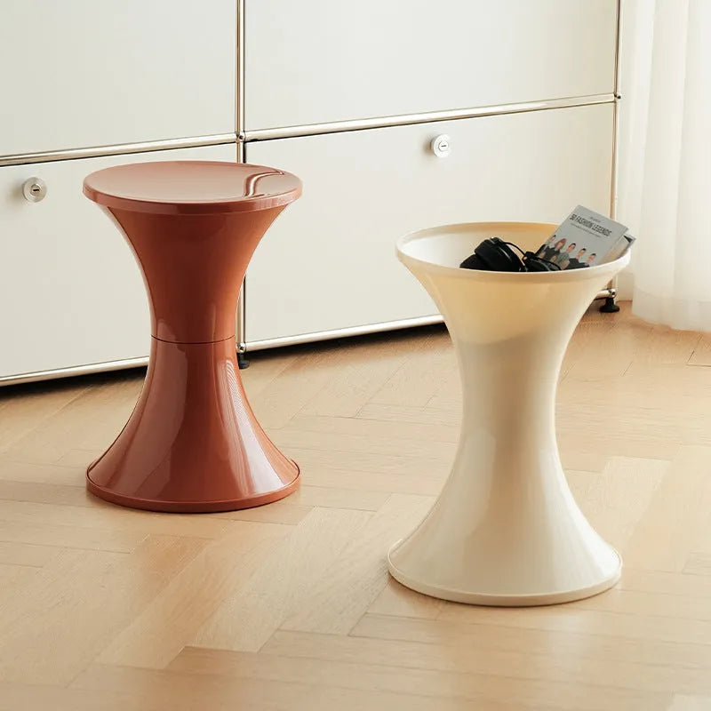 A plastic hourglass-style shoe changing stool in one of five available colours: black, green, red, white, or brown.